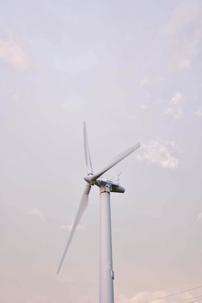 A solitary wind turbine standing against a clear sky, symbolizing renewable energy in Thailand.
